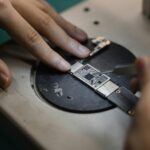 Detailed view of hands soldering electronic components, showcasing precision in engineering.